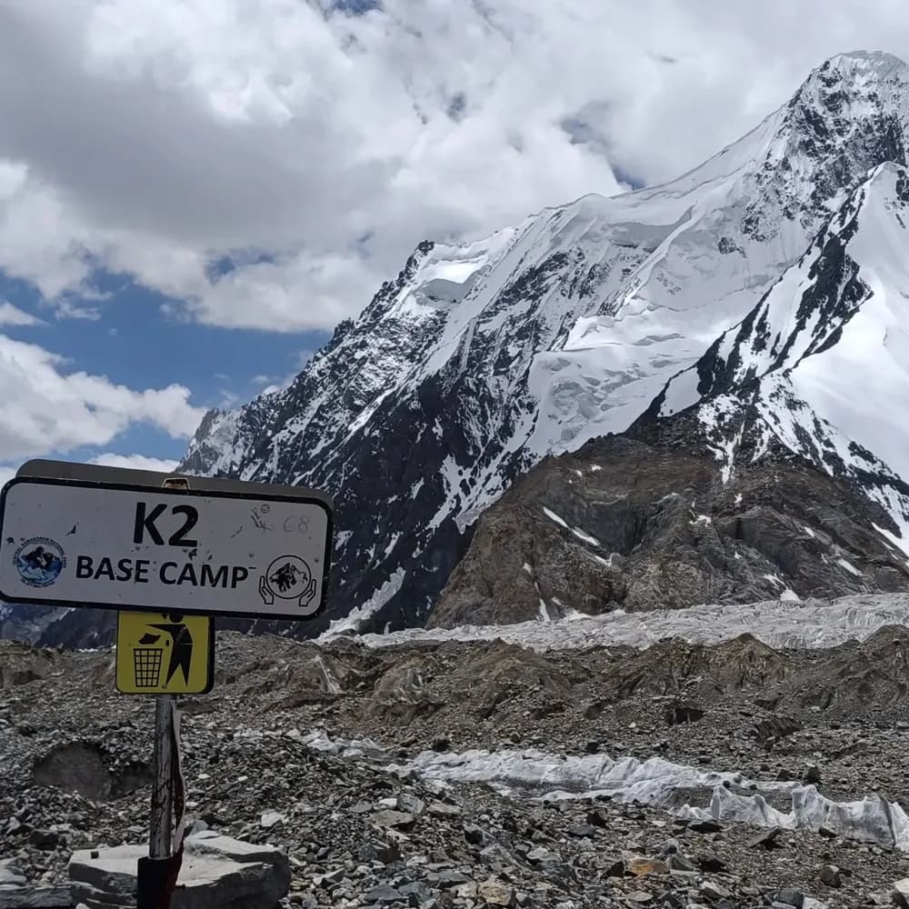 The K2 Base Camp signpost below the surrounding peaks