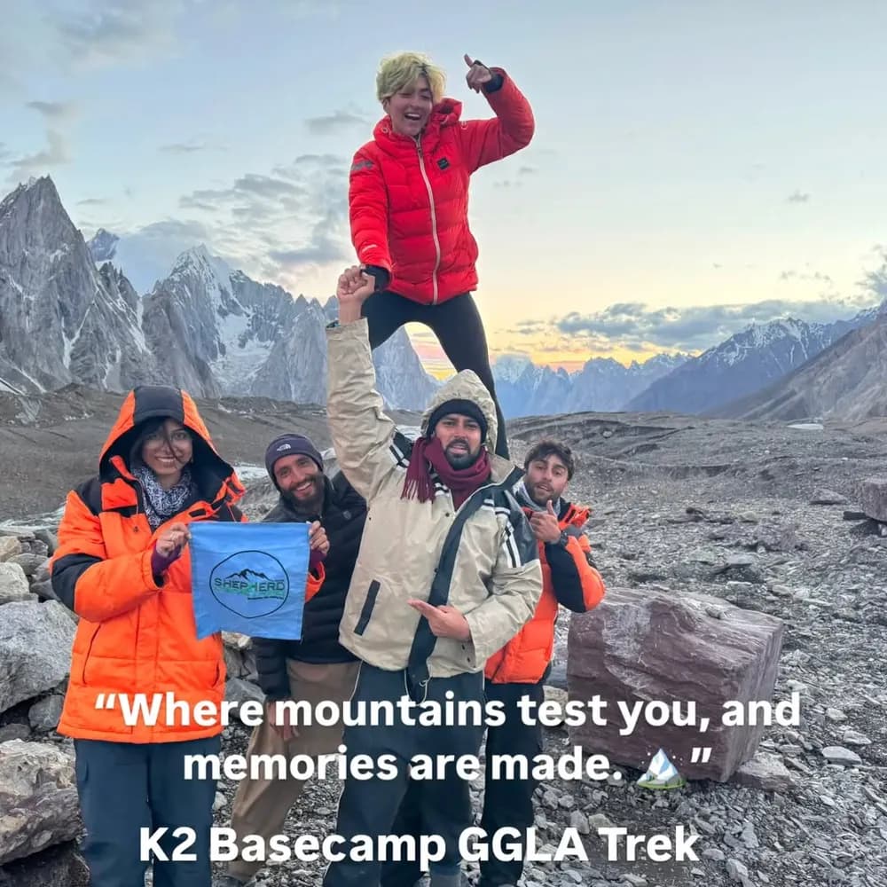 Trekking group celebrating at K2 Base Camp with a flag